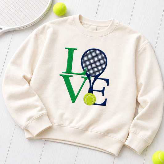 Ivory Tennis Love embroidered crewneck flat lay on white wood with tennis racket and balls